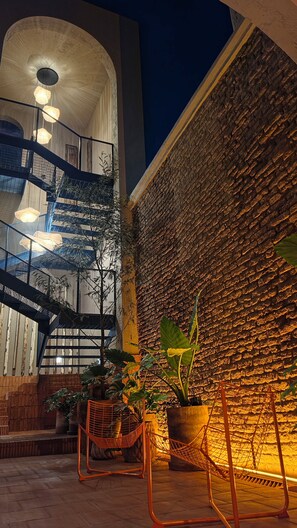 A multi-level interior with a staircase, potted plants, and a brick wall. - Loft Chic 2 Niveles Red Descanso Rooftop Grill Catedral Santuario S3 (Guadalajara)