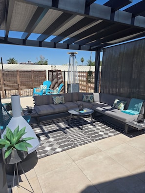 An outdoor patio with a sofa, coffee table, and a grill. - Private beautiful modern 400 sq ft studio located in a quiet neighborhood in SCW (Sun City West)