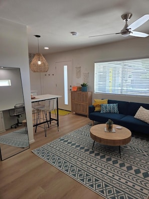 A modern living room with a sofa, coffee table, and dining area. - Private beautiful modern 400 sq ft studio located in a quiet neighborhood in SCW (Sun City West)