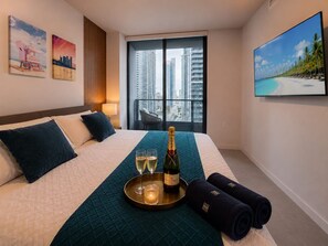 A hotel room with a bed, a city view, a balcony, and artwork on the walls. - Luxury 2BR Sky Retreat Best Miami Bay Views (Miami)