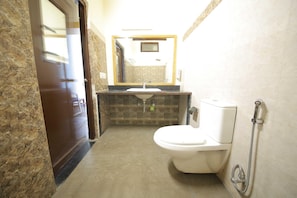 Une salle de bain avec des toilettes, un lavabo et une douche.