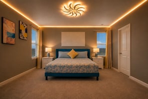 A bedroom with a bed, two bedside tables, a ceiling light fixture, and two windows with curtains.