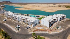 Ein modernes Hotel mit Pool in der Nähe einer Wüste und eines Gewässers.