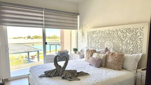 Ein Hotelzimmer mit einem großen Bett, einem verzierten Kopfteil, Blick ins Freie und einem Balkon.