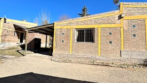A building with a brick facade, a satellite dish, and a covered area. - Nuestras Raíces Cabins (Las Vegas)