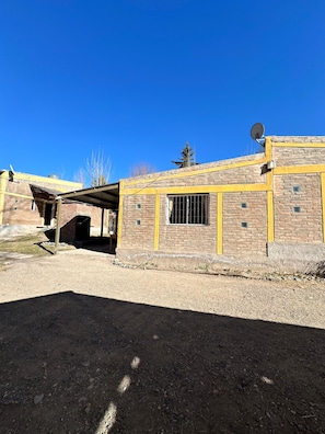 A building with a brick facade, a satellite dish, and a covered area.
