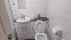 Ein Badezimmer mit Toilette, Waschbecken und Spiegel.