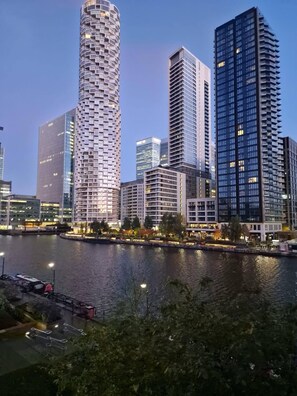 Eine Stadtsicht mit modernen Hochhäusern, einem Fluss und einem Kai mit Booten.