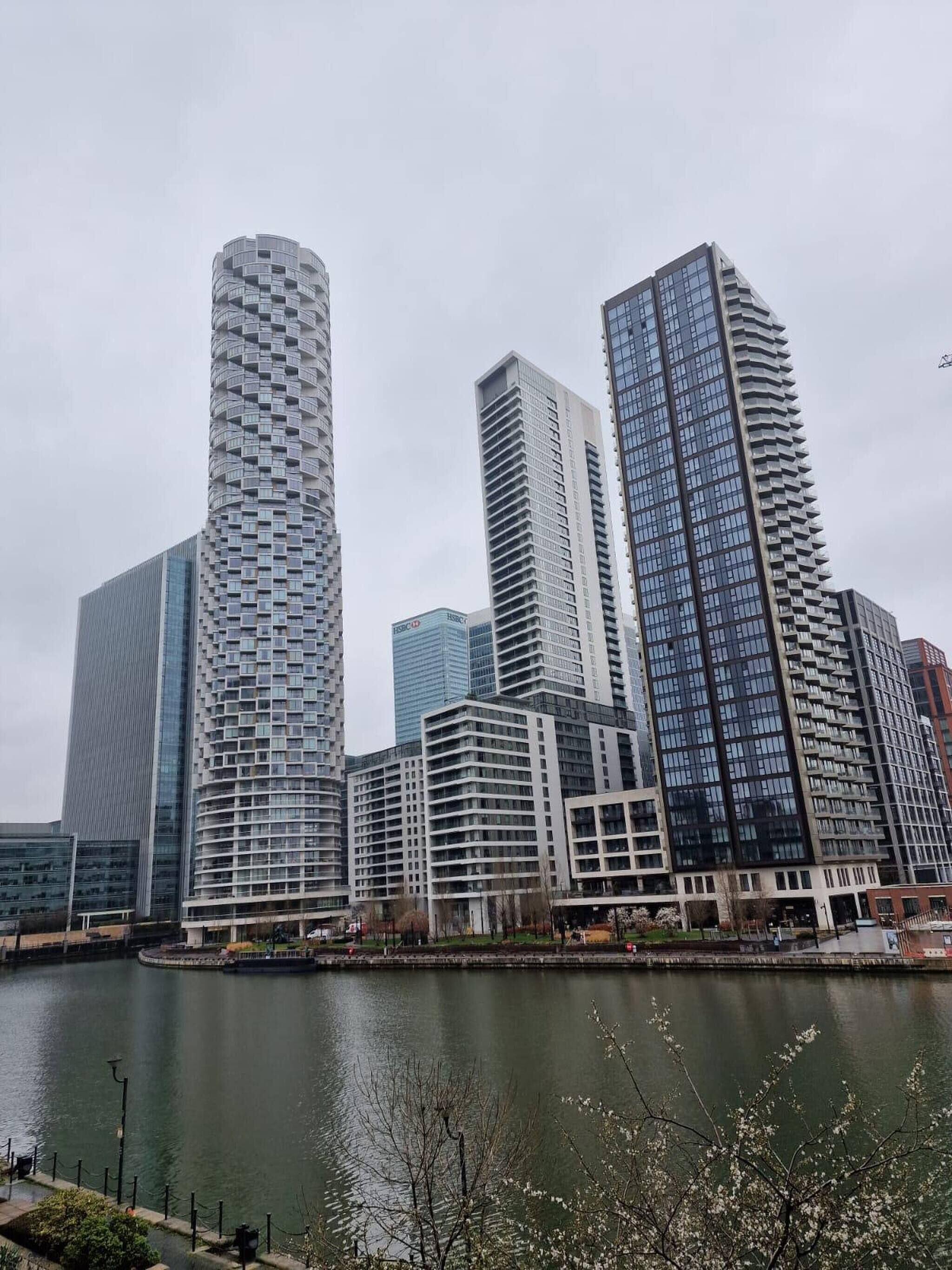 Un conjunto de edificios modernos de gran altura con una masa de agua al frente.