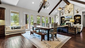 Un salon spacieux avec une grande table à manger, un canapé et une cheminée.