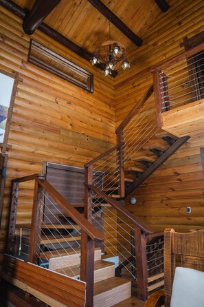 A wooden interior with a staircase, wooden beams, and a chandelier. - Luxurious Cabin Retreat in Las Jarabacoa With Private Pool, EL Reloj SE Detuvo (Jarabacoa)