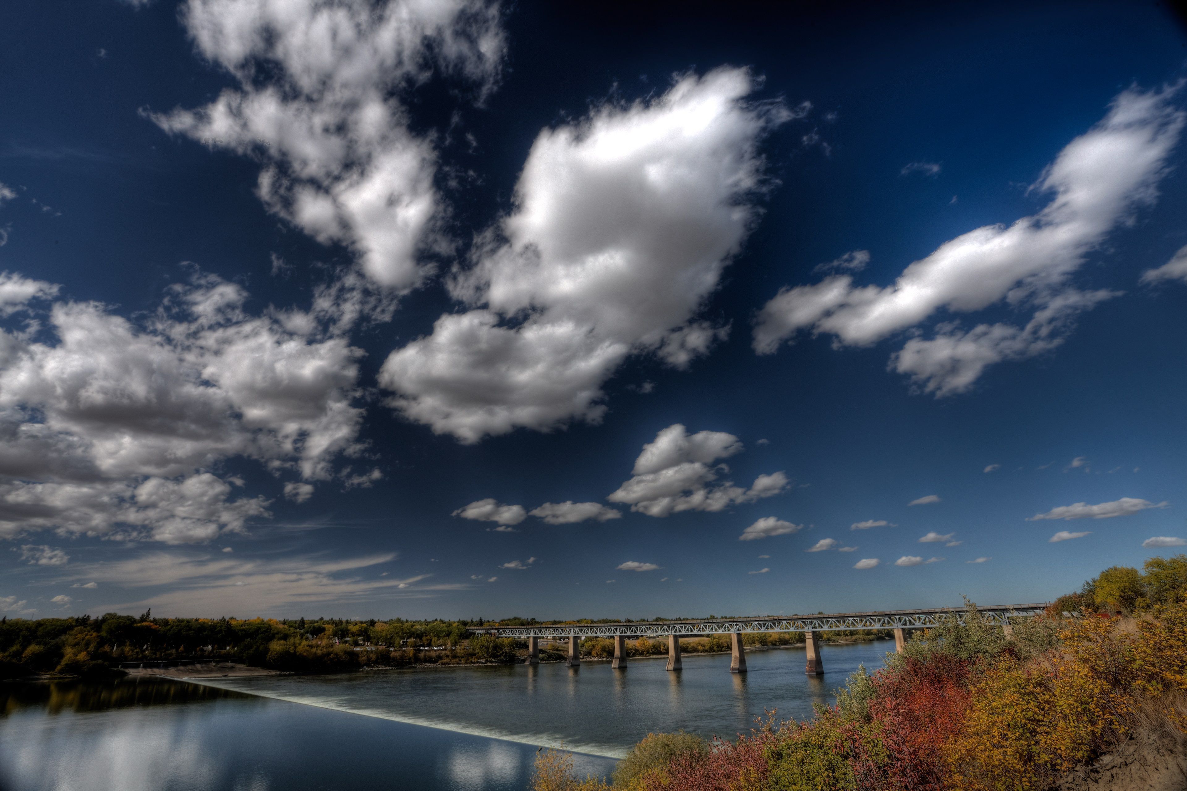 Un pont enjambant une rivière paisible, sous un ciel dégagé.