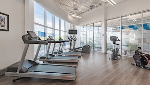 Ein Fitnessraum mit Laufbändern, Crosstrainern und einem Ergometer.