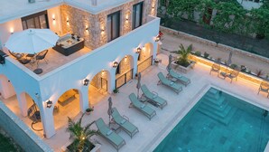 A rooftop pool area with lounge chairs, a hot tub, and stone walls. - B&B Lovac  (Ulcinj)