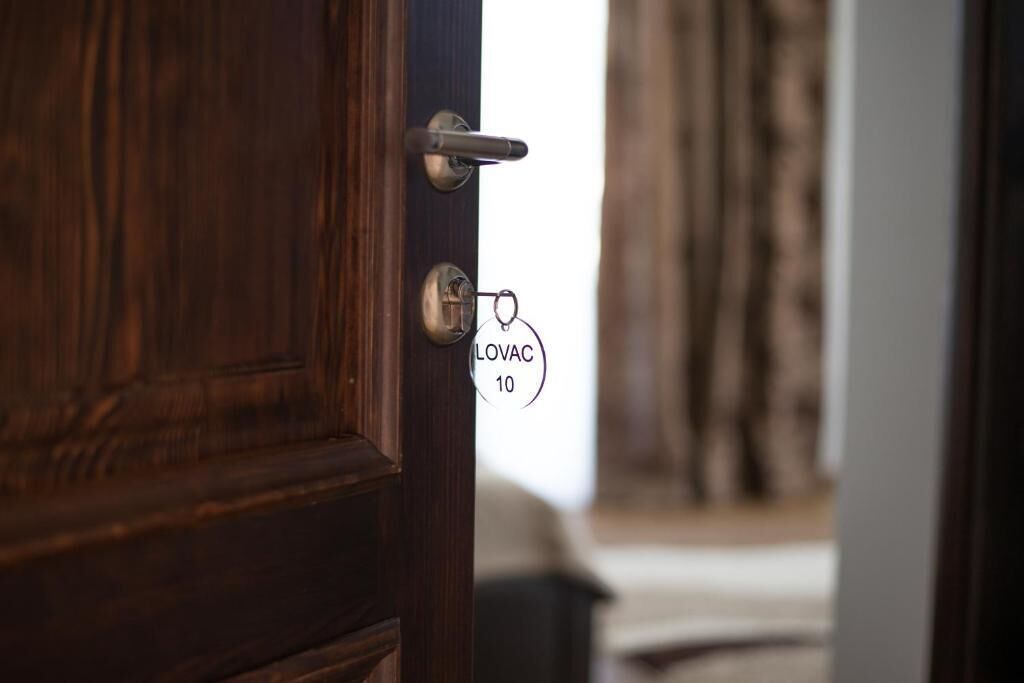 A wooden door with a keyhole and a keychain with a name tag.