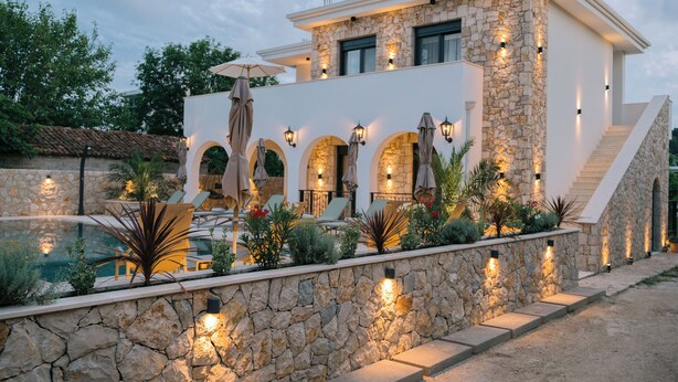 A modern house with a stone facade, outdoor seating, and a pool. - B&B Lovac  (Ulcinj)