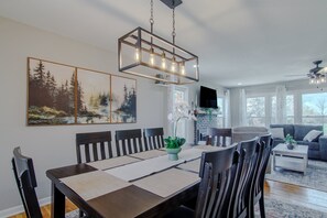 A dining area with a rectangular table, chairs, a hanging light fixture, and artwork on the wall. - Truman Lake Country Home: Circle Drive for Boats/Trailers & Family Friendly (Clinton)