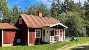 A red wooden house with a porch, a chimney, and a satellite dish. - 5 Person Holiday Home in Kristdala (Kristdala)