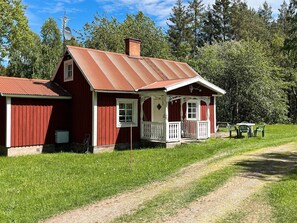 A red wooden house with a porch, a chimney, and a satellite dish. - 5 Person Holiday Home in Kristdala (Kristdala)