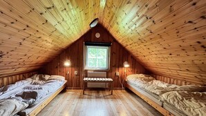 A cozy attic bedroom with two single beds, a window, and a desk. - 5 Person Holiday Home in Kristdala (Kristdala)