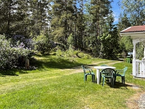 A grassy outdoor area with a white gazebo, green plastic chairs, and a table. - 5 Person Holiday Home in Kristdala (Kristdala)