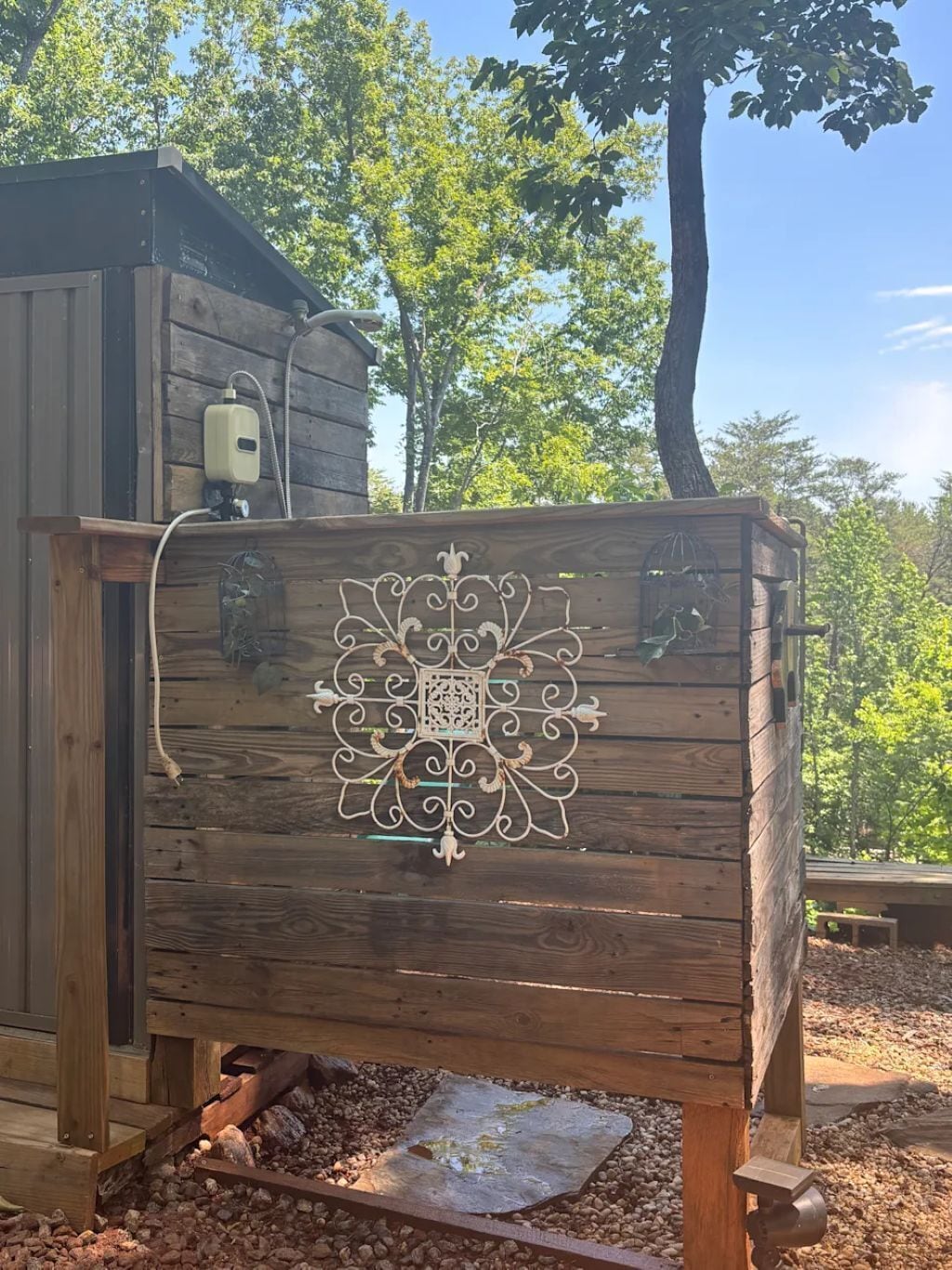 A wooden structure with a decorative metal panel, a small window, and a hose.. Mountain view - Marvelous campground in Columbus perfect for your next adventure