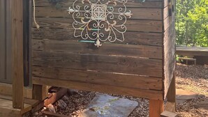 A wooden structure with a decorative metal panel, a small window, and a hose. - Mountain view - Marvelous campground in Columbus perfect for your next adventure (Columbus)