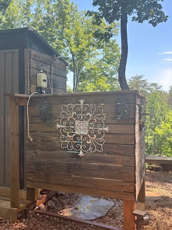 A wooden structure with a decorative metal panel, a small window, and a hose.. Mountain view - Marvelous campground in Columbus perfect for your next adventure