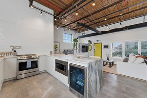 Een moderne keuken met inbouwapparatuur, een groot eiland en uitzicht op de stad.