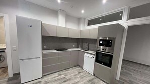 Una cocina moderna con horno empotrado, microondas y lavavajillas.