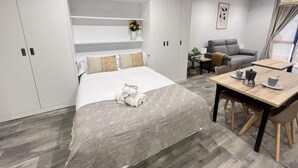 Una habitación de hotel moderna con una cama grande, una zona de comedor y un área de estar.