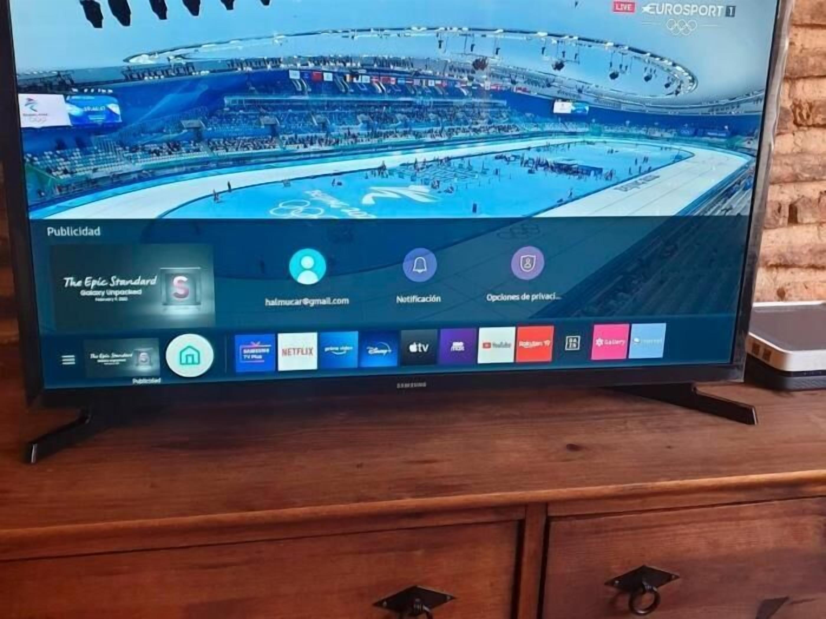 A television displaying a Eurosport channel with a view of a large indoor stadium.