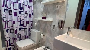 Een badkamer met toilet, bidet en wastafel.