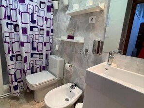 Un baño con inodoro, bidé y lavamanos.
