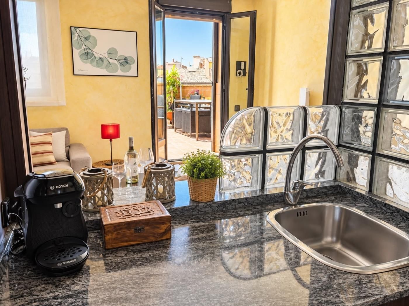 A kitchen with a Bosch coffee maker, a sink, and a view of the outside.