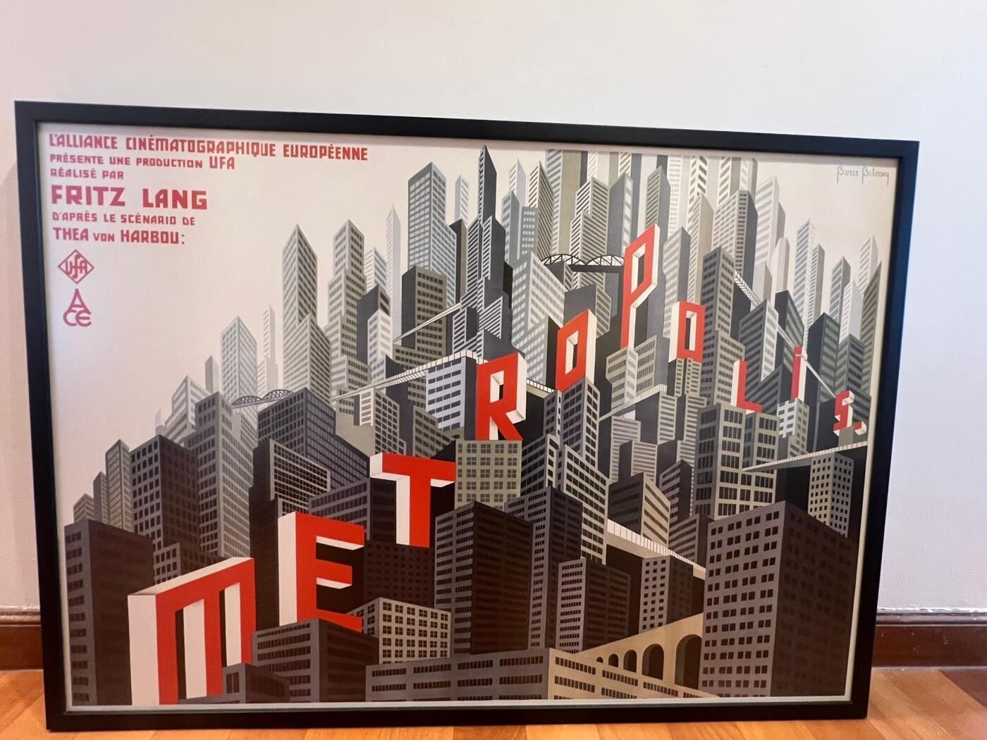 A framed artwork of a cityscape with the word 'METROPOLIS' prominently displayed.