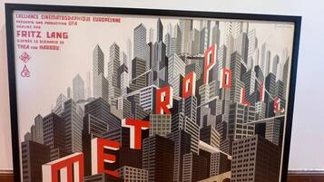 A framed artwork of a cityscape with the word 'METROPOLIS' prominently displayed.