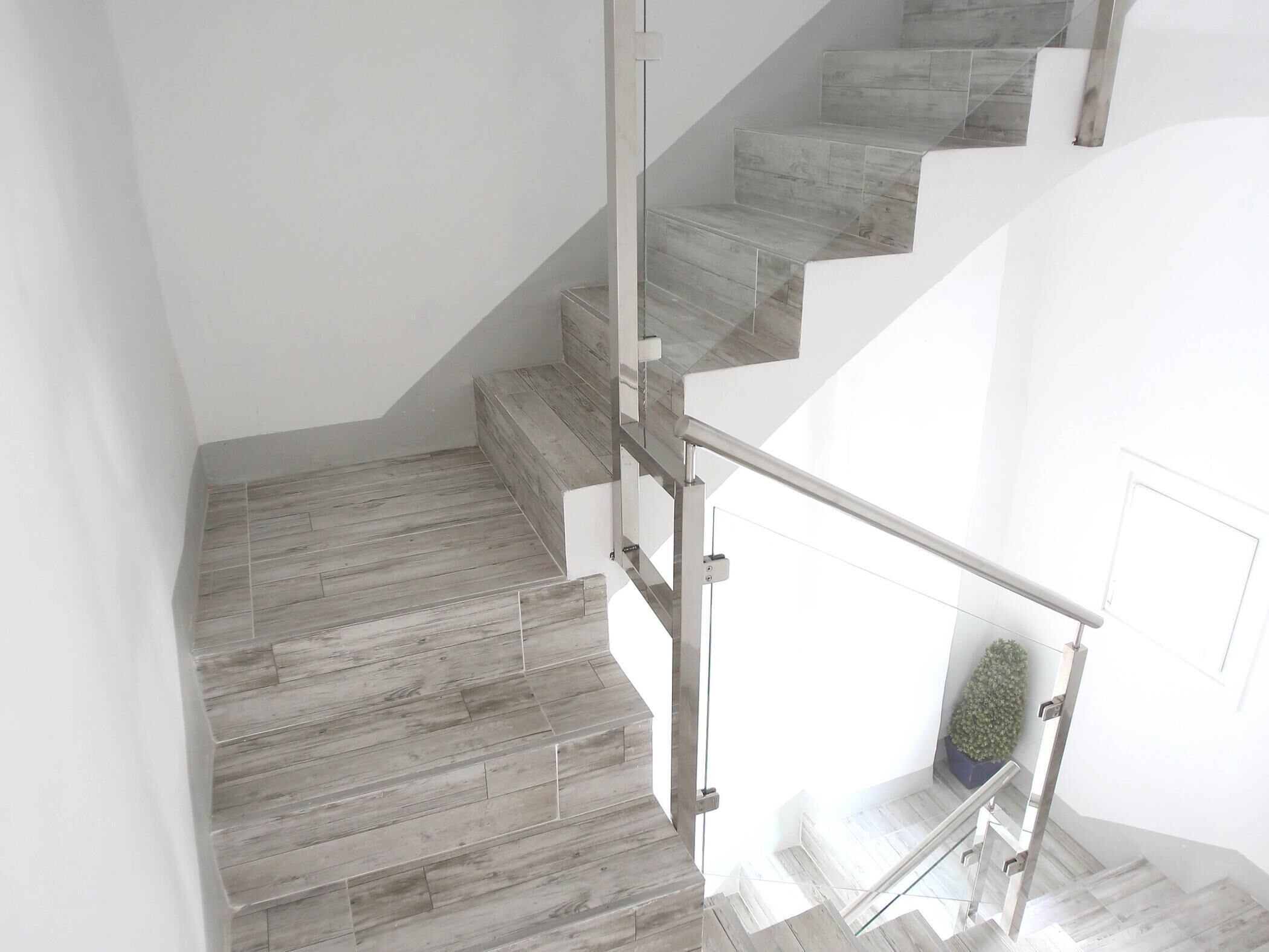 A staircase with wooden steps and a glass railing.