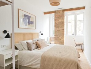 A bedroom with a bed, bedside tables, a chair, a window, and a wall-mounted artwork. - DANIELAS´S LOVELY APARTMENT. Aire y wifi (Logroño)