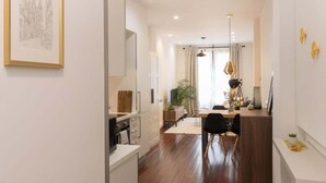 A modern kitchen with white cabinets, a wooden countertop, and a black microwave. - Los apartamentos de Elena, centro histórico I by El Rincon (Logroño)