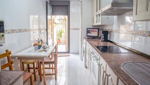 Una cocina con comedor, televisor y ventana.