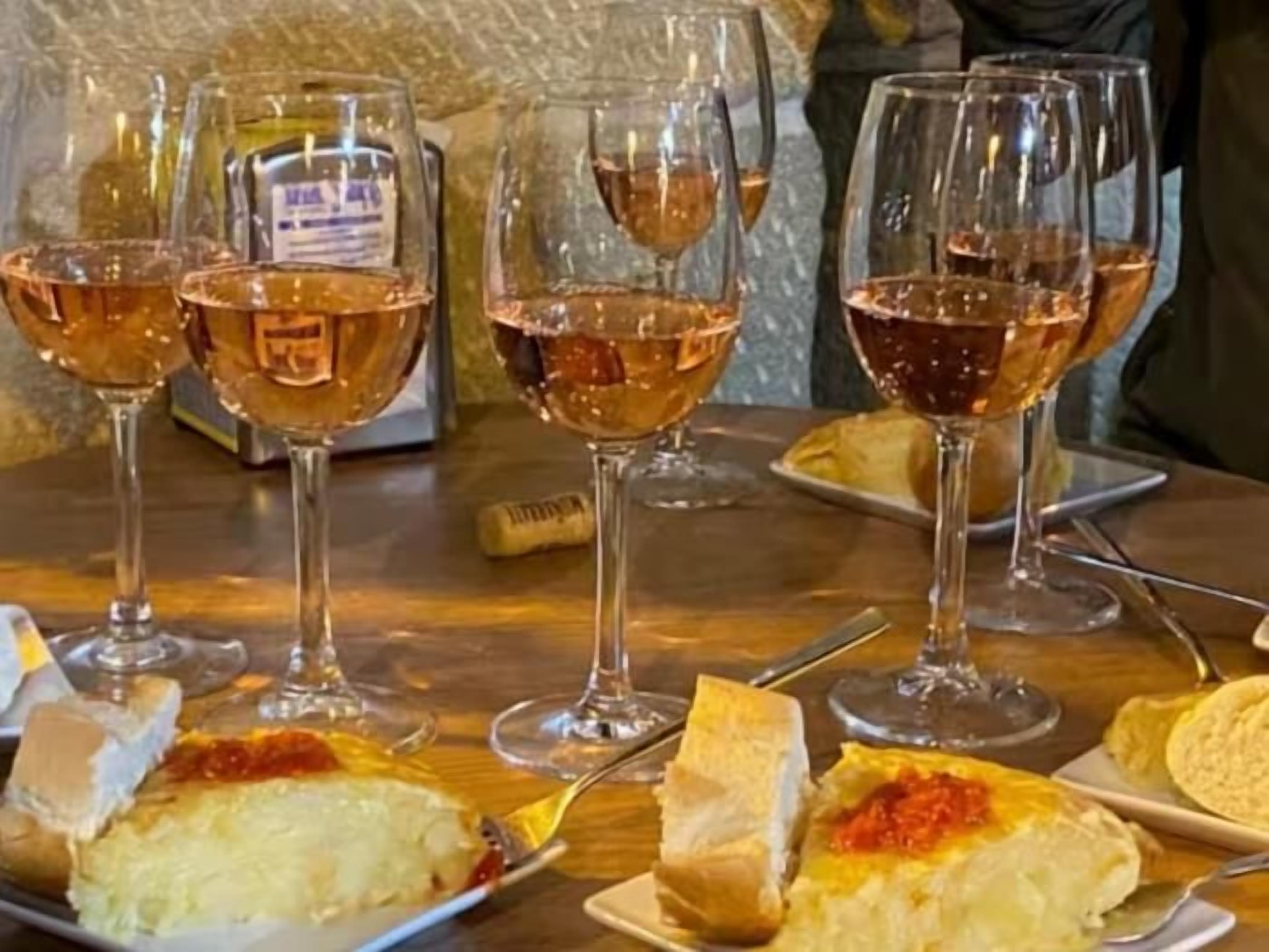 A table with wine glasses, plates of food, and a bottle of wine.