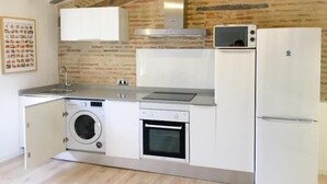 Una cucina compatta con lavatrice, forno e microonde integrati.