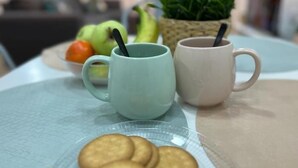 A table with two mugs, a plate of cookies, and a bowl of fruit. - El Rincón del Marqués by El Rincon (Logroño)