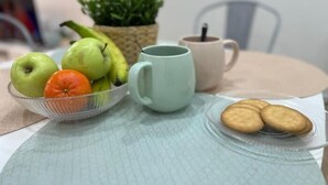 A table with a bowl of fruit, a mug, and a plate of cookies. - El Rincón del Marqués by El Rincon (Logroño)
