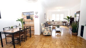 En rummelig opholdsstue med spisebord, sofa og sofabord.