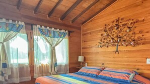 A wooden cabin bedroom with a bed, bench, and a wall-mounted tree decoration. - La CABAÑA TABACHIN RELAXATION FOR COUPLES JACUZZI & ALBERCA (Yautepec de Zaragoza)
