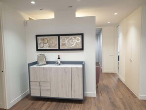 Een moderne badkamer met een wastafel, een spiegel en twee lijstwerken met abstracte kunst aan de muur.
