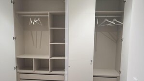 Et garderobrum med mange hylder, plads til ophængning og skuffer.