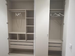 Ein begehbarer Kleiderschrank mit mehreren Regalen, Ablageflächen und Schubladen.
